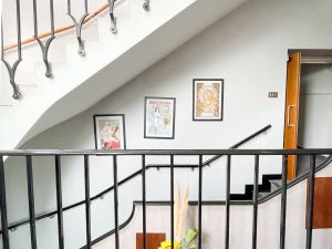 framed art on a wall behind a staircase