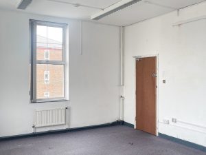 blue carpeted room with white walls and brown wooden door