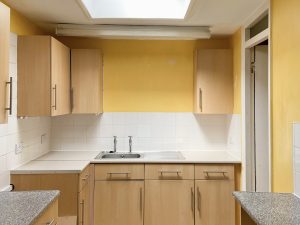 kitchen with yellow wall and brown wooden cabinets