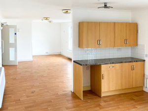 wooden cabinets in white-walled room with wooden floor