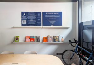 blue signs on a white wall above a bookcase