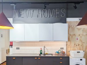 kitchen counter with the words 'new home' in a turned off neon sign above the cupboards