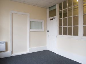 white door in corner of a room next to indoor window