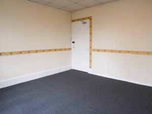 white walled corner of a room with yellow wallpaper strips around the doorframe