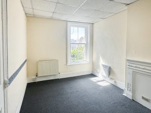 white walled room with a white framed window and white fireplace