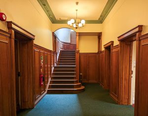 wooden staircase in a room with a chandalier