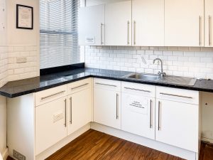 white kitchen cabinets with a black countertop