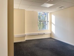 white walled room with window with a tree outside