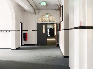 hallway with white walls and blue carpeted floor