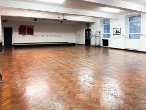 large room with wooden floor, white walls