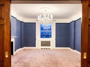 room with carpeted floor, chandelier and dark blue walls