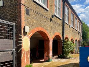 red and brown brick building with yellow sun painted on it