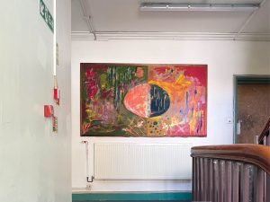 a red and green painting on a white wall