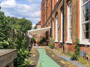 an outdoor play area with a green and yellow road painted on the concrete ground