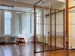 a school gym with a wooden frame and ropes hanging from ceiling