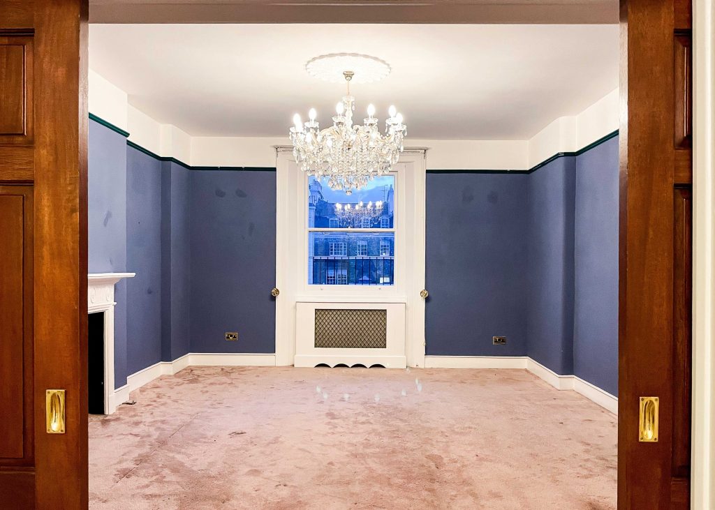 blue walled room with white chandalier 