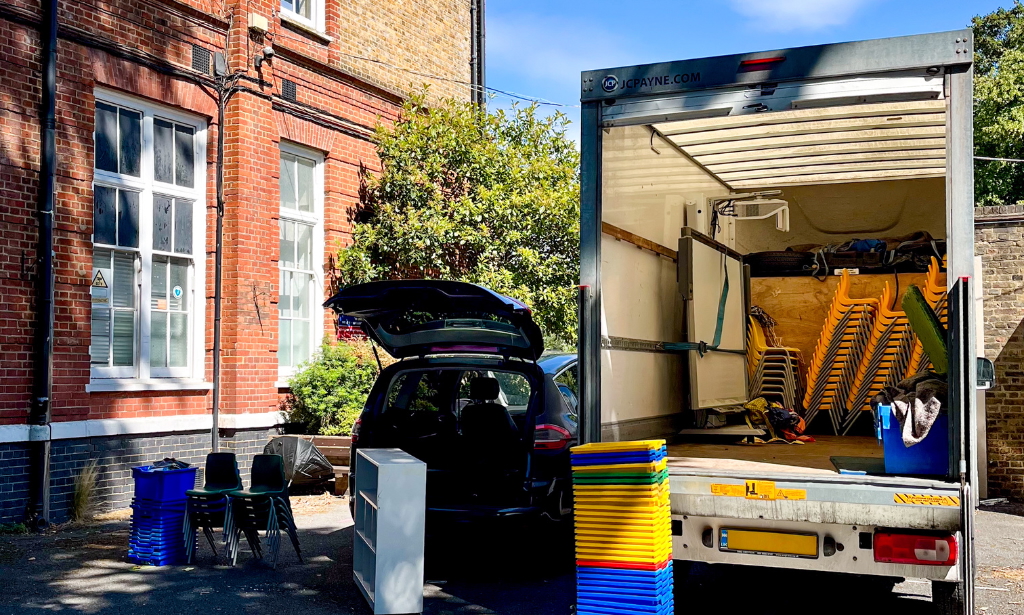 a parked van with stacked furniture next to it.