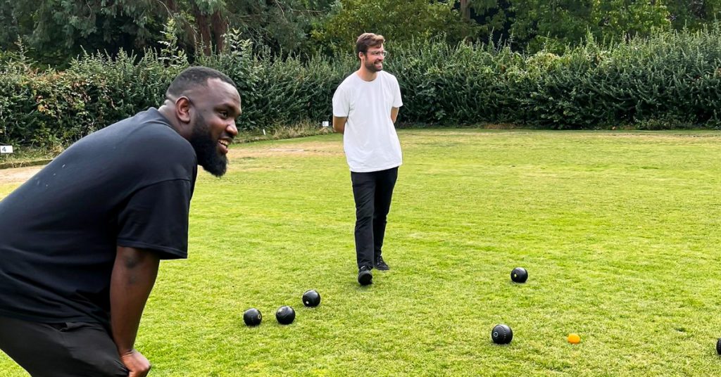 two men on a field with lawn bowls on it